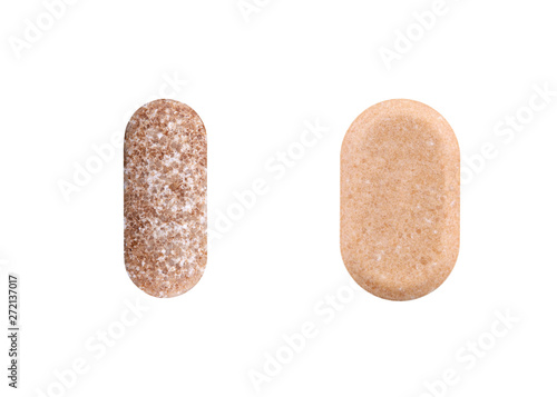 Two brown oval pills isolated on white background