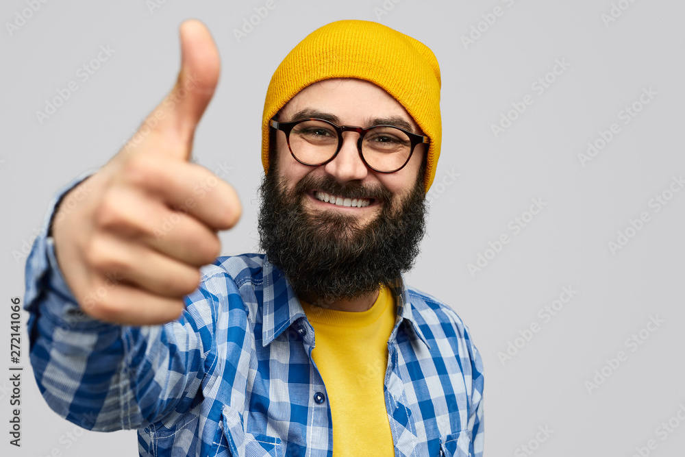 Confident hipster gesturing thumb up Confident hipster gesturing thumb up