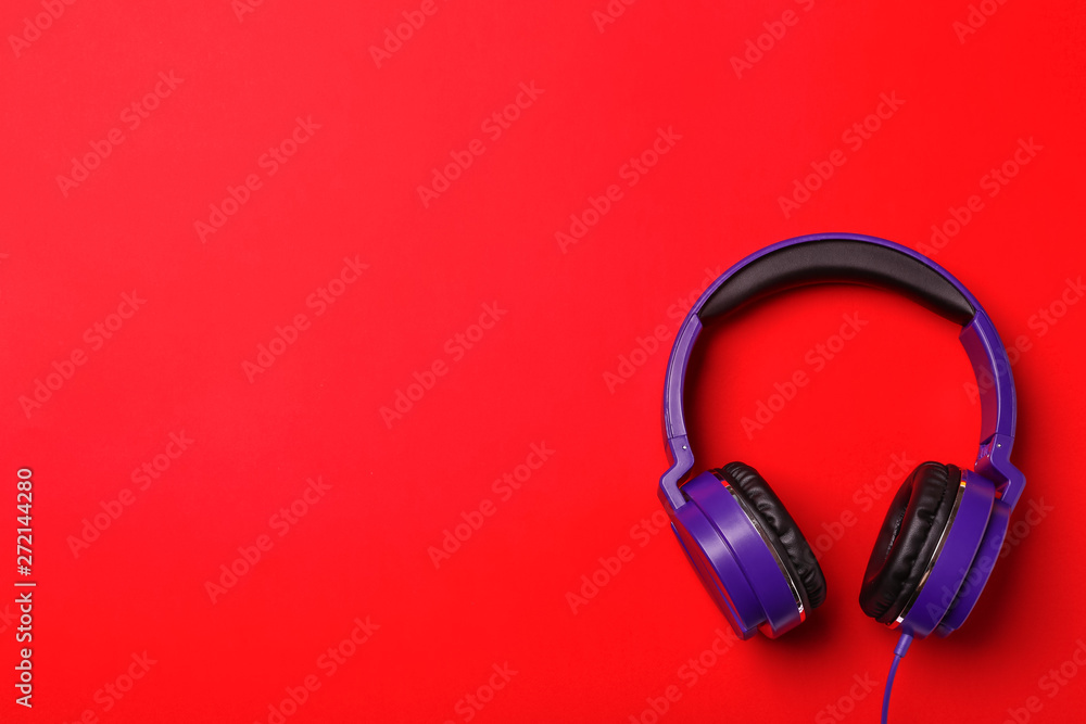 Stylish modern headphones on color background, top view. Space for text Stylish modern headphones on color background, top view. Space for text