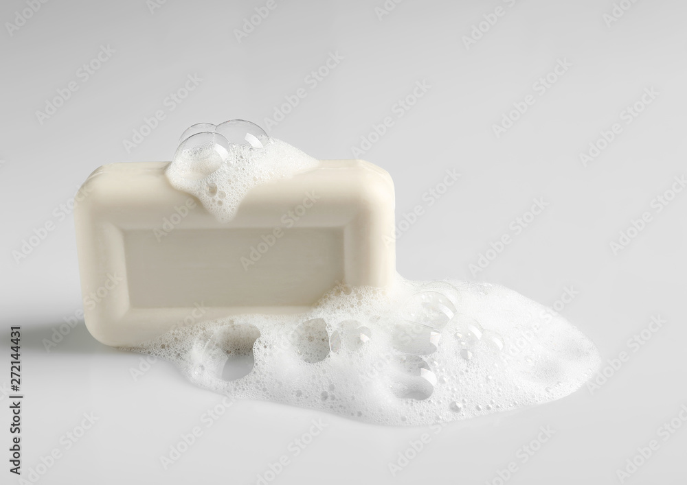 Soap bar and foam on white background