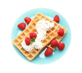 Plate with yummy waffles, whipped cream and raspberries on white background, top view