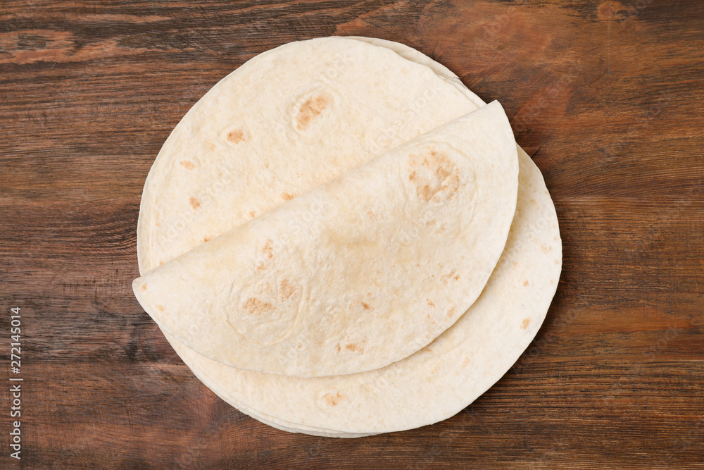 Corn tortillas on wooden background, top view. Unleavened bread Corn tortillas on wooden background, top view. Unleavened bread