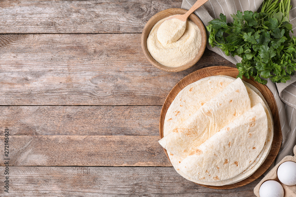 Flat lay composition with corn tortillas on wooden background, space for text. Unleavened bread Flat lay composition with corn tortillas on wooden background, space for text. Unleavened bread