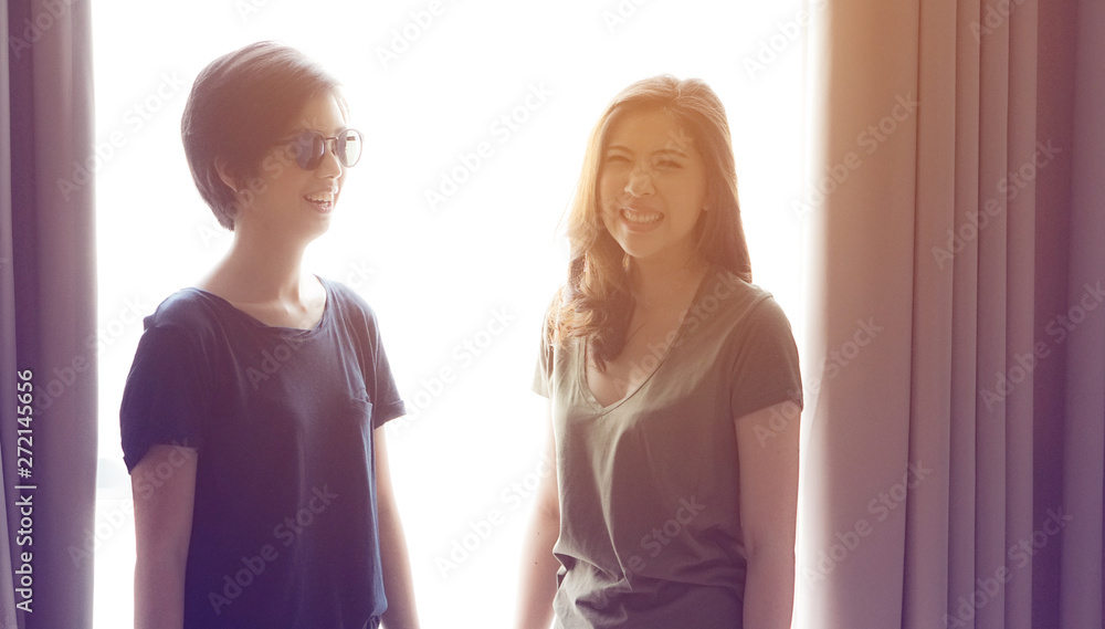 Happy ethnic Asian friends smiling at window light Happy ethnic Asian friends smiling at window light