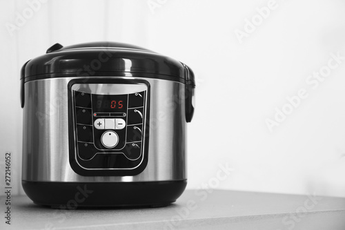 Modern multi cooker on table. Space for text