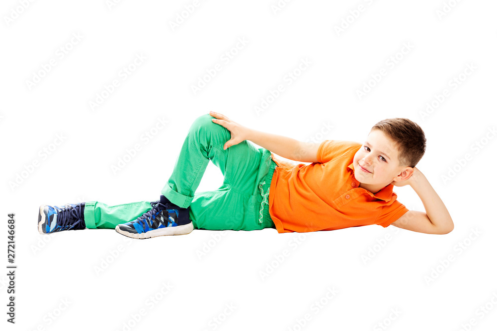 A smiling school boy in an orange T-shirt is lying on his side. Isolated on a white background. A smiling school boy in an orange T-shirt is lying on his side. Isolated on a white background.