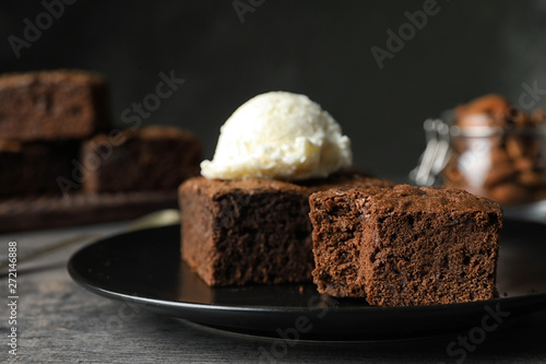 Fresh brownies served with ice-cream on table  space for text. Delicious chocolate pie