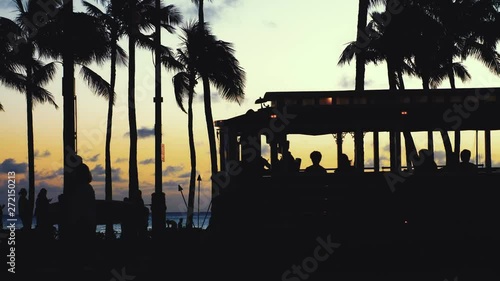 Tourists walking at sunset in Waikiki beach in 4k photo