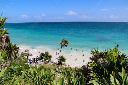 Palm trees, white sandy beach and turquoise water in Tulum beach, Mexico