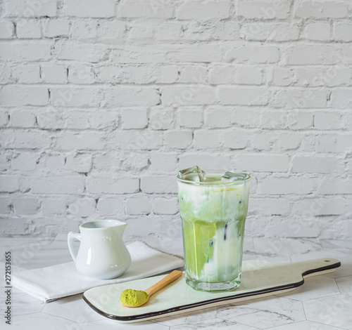 Matcha green tea latte with matcha powder and wooden spoon . 