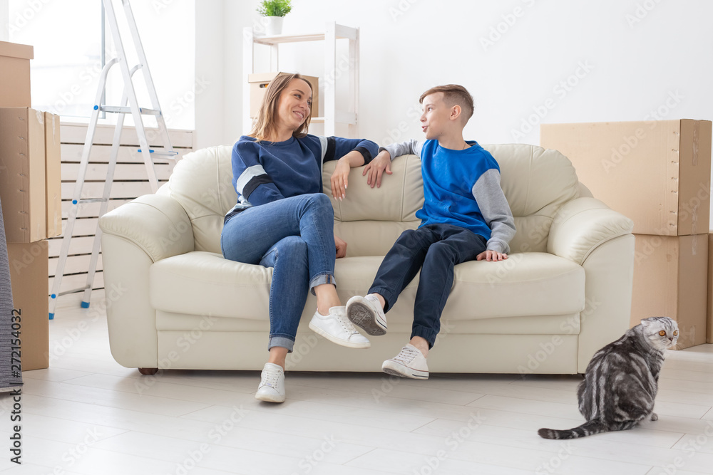 Satisfied happy caucasian mother and son happily communicate discussing the deisgn of the new apartment during the housewarming party with their scottish fold cat. Satisfied happy caucasian mother and son happily communicate discussing the deisgn of the new apartment during the housewarming party with their scottish fold cat.