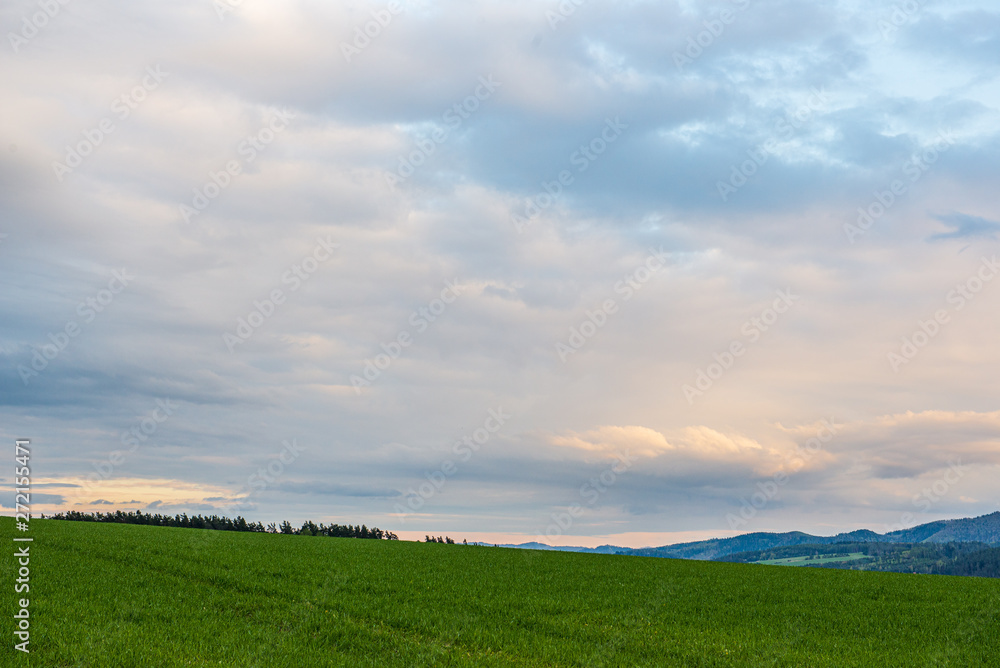 countryside landscape under blue sky and dramatic white clouds