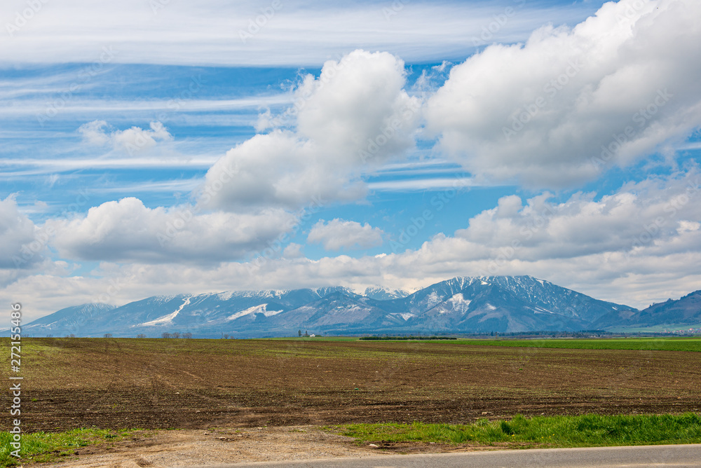 Obraz premium countryside landscape under blue sky and dramatic white clouds