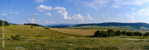countryside landscape under blue sky and dramatic white clouds