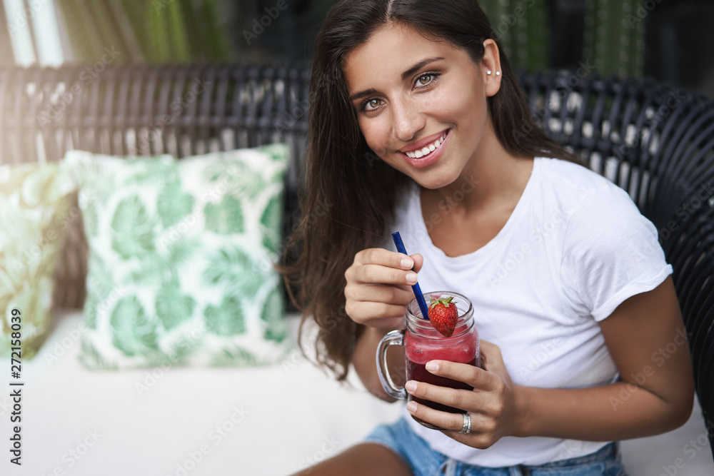 © Liubov Levytska - Alluring young european tanned woman nice flirty smile drinking beverage sit outdoor cafe terrace sofa look up smiling talking boyfriend, have date outside, enjoy smoothie relax weekends © Liubov Levytska - Alluring young european tanned woman nice flirty smile drinking beverage sit outdoor cafe terrace sofa look up smiling talking boyfriend, have date outside, enjoy smoothie relax weekends