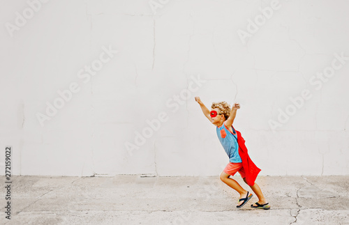 Little boy wearing cape dressed up like a superhero