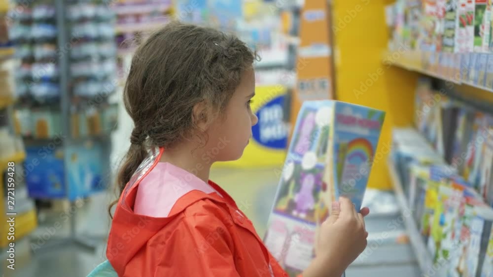 Little girls buy books in the supermarket Little girls buy books in the supermarket