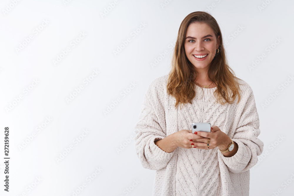 Studio shot charming happy smiling woman holding smartphone looking camera positive grinning communicating using app featurused. Female blogger posting pic online smm working via phone Studio shot charming happy smiling woman holding smartphone looking camera positive grinning communicating using app featurused. Female blogger posting pic online smm working via phone