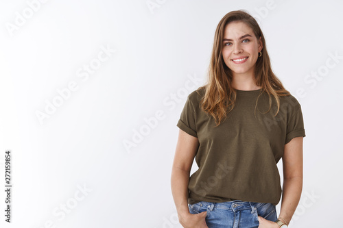 Attractive modern young urban woman chestnut short haircut wearing olive t-shirt holding hands pockets smiling friendly relaxed sound-minded pose, outgoing woman communicating grinning