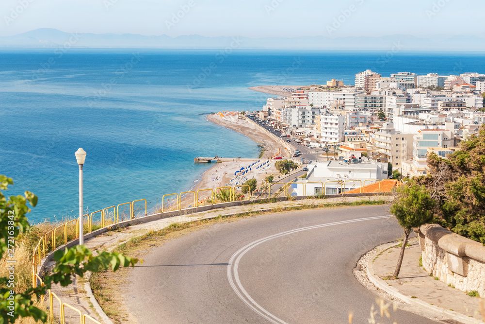 Winding road and Rhodes resort town and azure sea bay