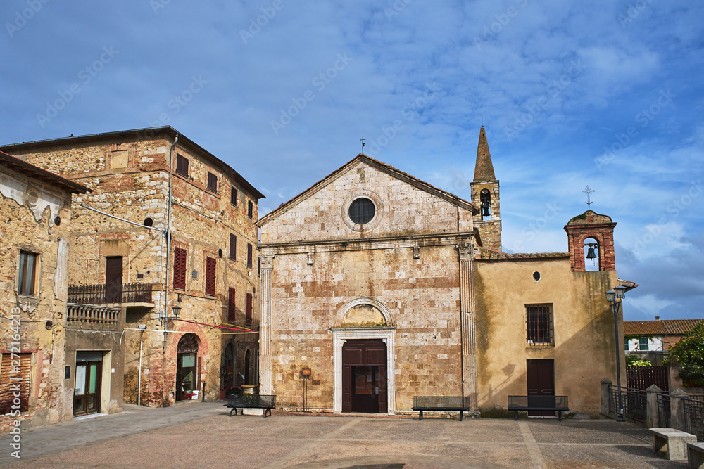 Stone, medieval church with a bell tower in the village of Magliano in Toscana, Italy.