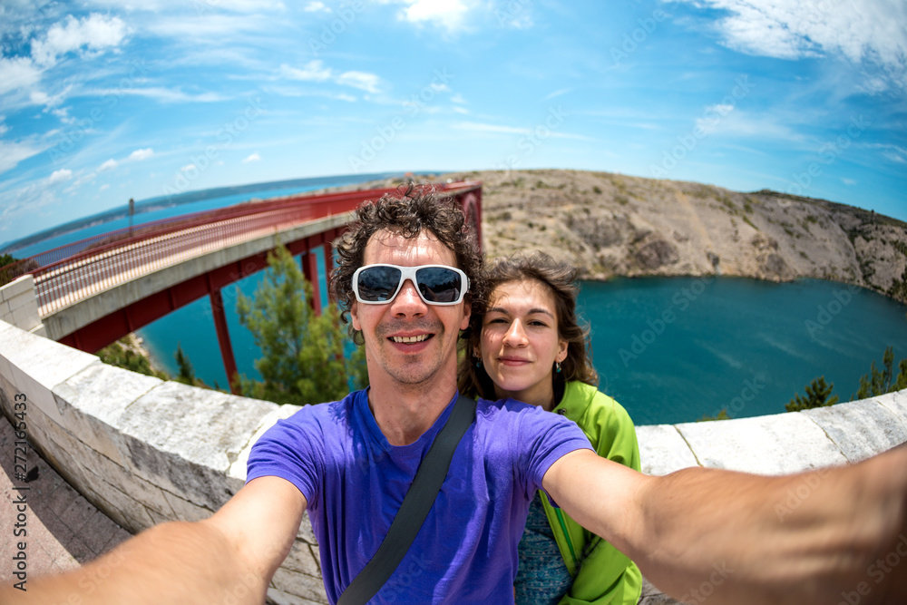 A couple takes a selfie on the bridge.