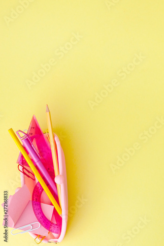 Back to school concept with space for text. Top view. Copy space. School office supplies.Creative desk with colourful stationery. Colored paper clip.School supplies on yellow background.Office desk