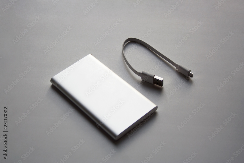 Portable aluminum power bank with USB cable isolated on white background Portable aluminum power bank with USB cable isolated on white background