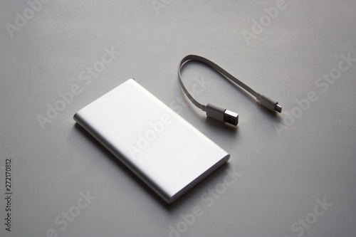 Portable aluminum power bank with USB cable isolated on white background