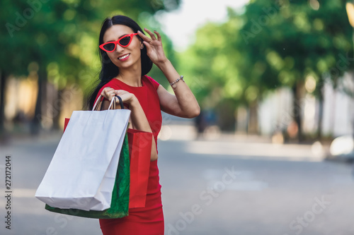 Portrait of young happy smiling woman with shopping bags enjoying in shopping. Positive emotions and Shopping day concept.