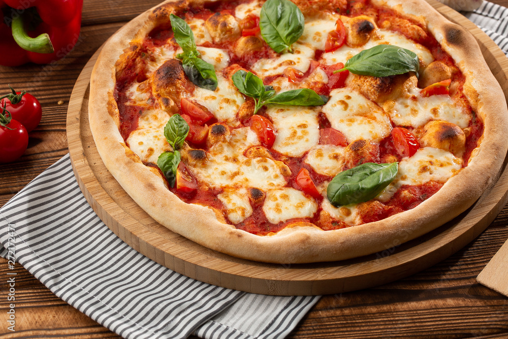 Pizza Margherita on wooden background, top view. Pizza Margarita with Tomatoes, Basil and Mozzarella Cheese close up. 