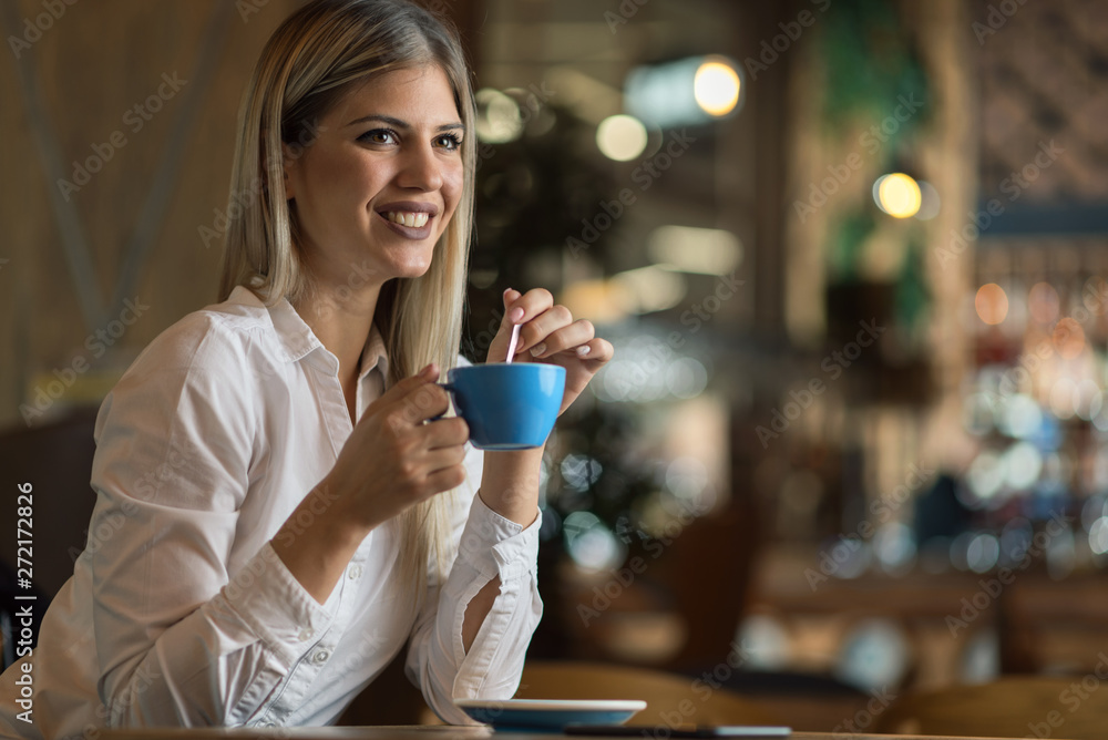 Happy woman enjoying in a cup of coffee and day dreaming