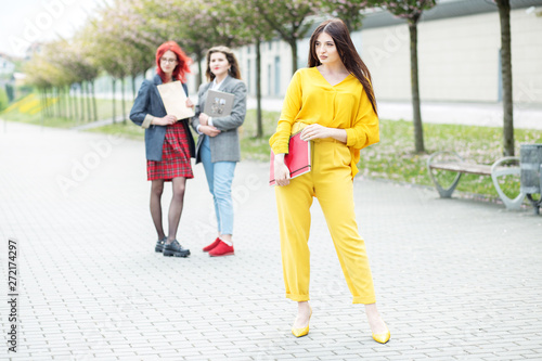 Beautiful student standing with a folder. Education concept, exams, friendship and group of people