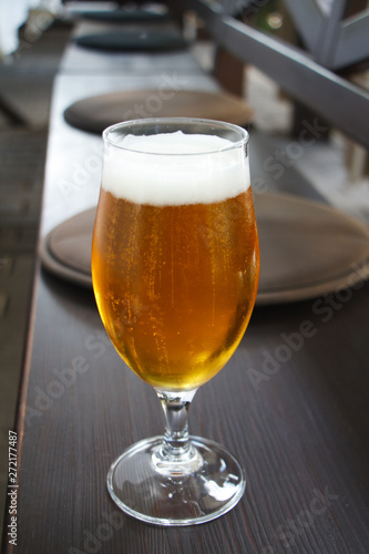 Closeup of a glass of light beer on the bar, summer vacation concept, selective focus