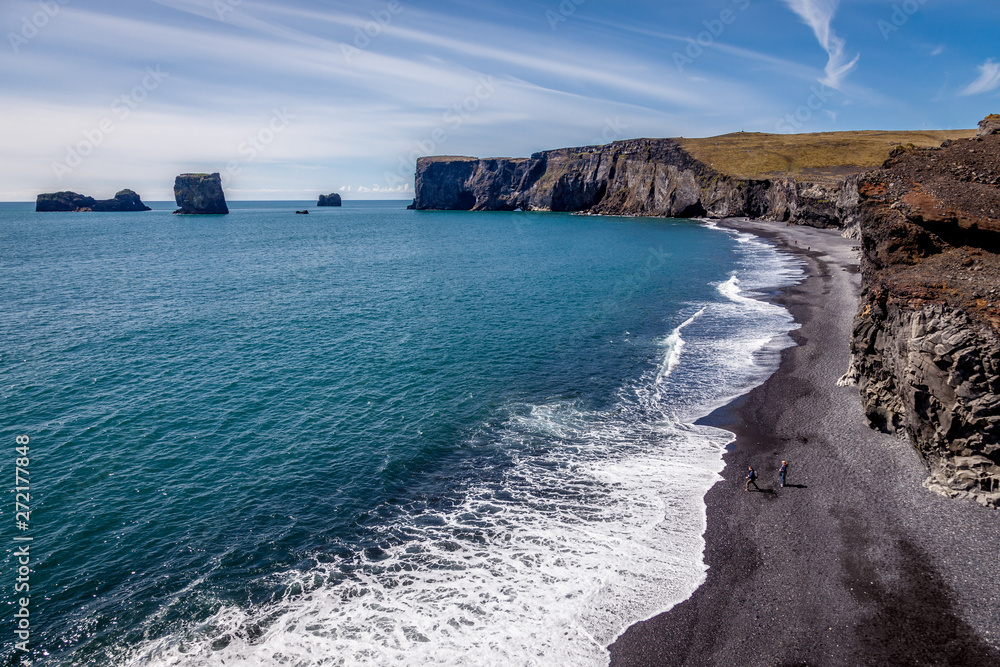 Obraz premium Beautiful sunny day at the coast in Dyrholaei Iceland with black sand and cliffs