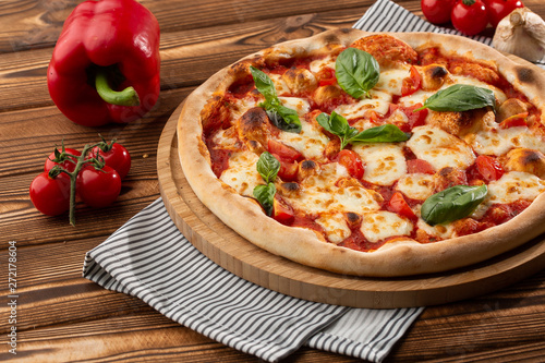 Pizza Margherita on wooden background, top view. Pizza Margarita with Tomatoes, Basil and Mozzarella Cheese close up. 