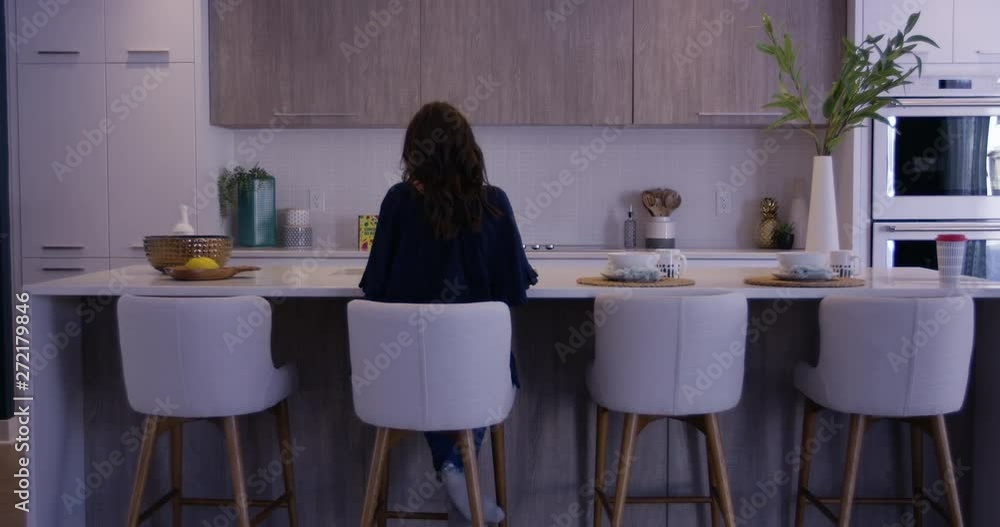 Woman working on kitchen counter - wide shot - from behind slowly zoom in Woman working on kitchen counter - wide shot - from behind slowly zoom in