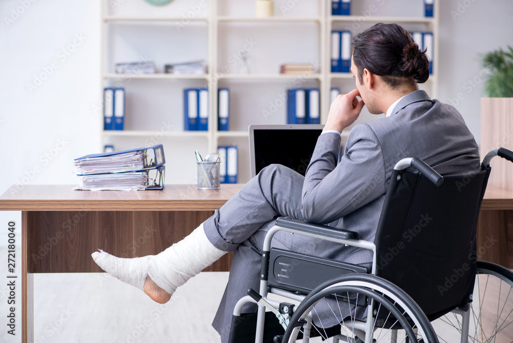 Male employee in wheel-chair in the office Male employee in wheel-chair in the office