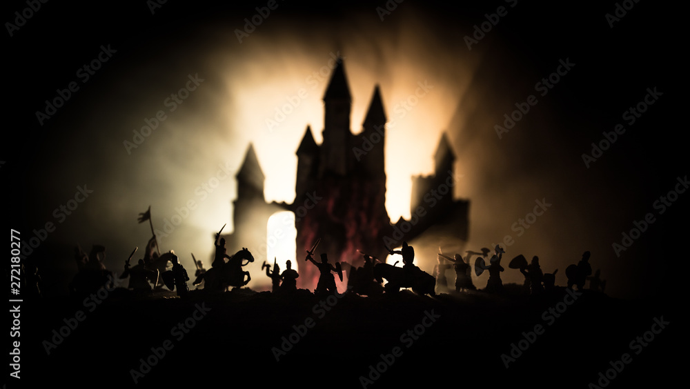 Medieval battle scene with cavalry and infantry. Silhouettes of figures as separate objects, fight between warriors on dark toned foggy background with medieval castle.
