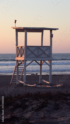 lifeguard tower on the beach at sunset