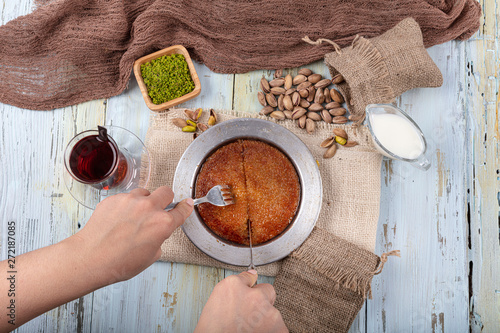 Turkish dessert kunefe, kunafa, kadayif with pistachio powder and cheese, served hot, very sweet. Turkish traditional dessert. photo