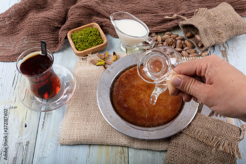 Turkish dessert kunefe, kunafa, kadayif with pistachio powder and cheese, served hot, very sweet. Turkish traditional dessert. photo