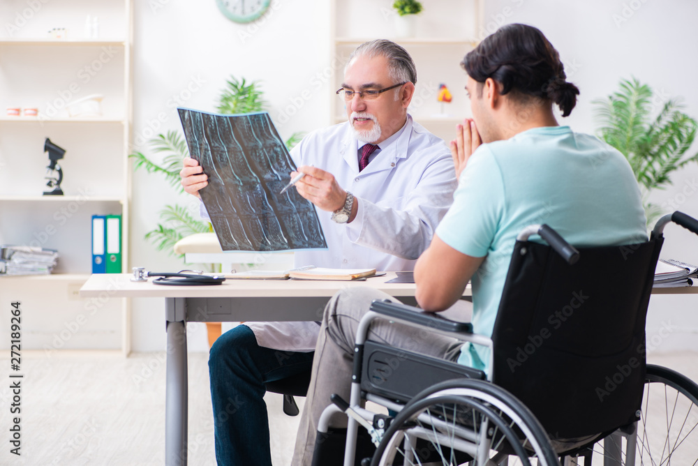 Male patient in wheel-chair visiting old doctor 