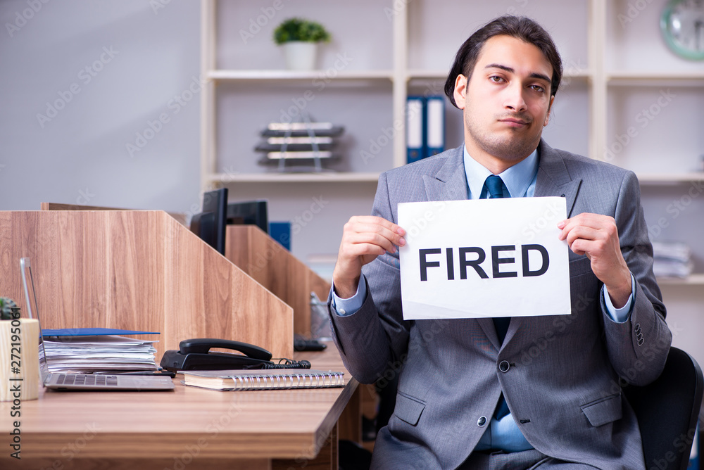 Young male employee being fired from his work Young male employee being fired from his work
