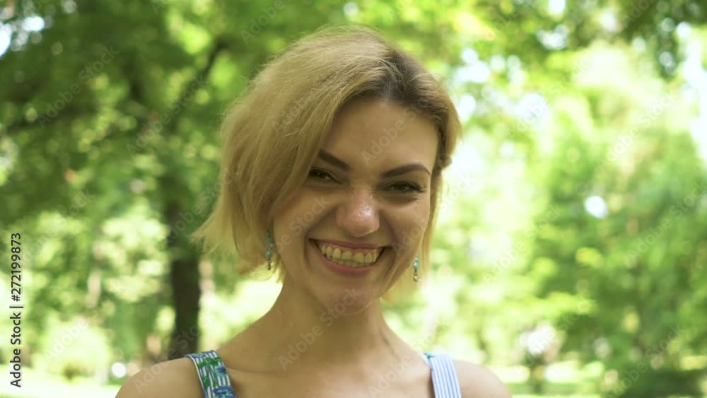 4k. Pretty caucasian woman brightly laughs in summer city park. Face portrait 4k. Pretty caucasian woman brightly laughs in summer city park. Face portrait