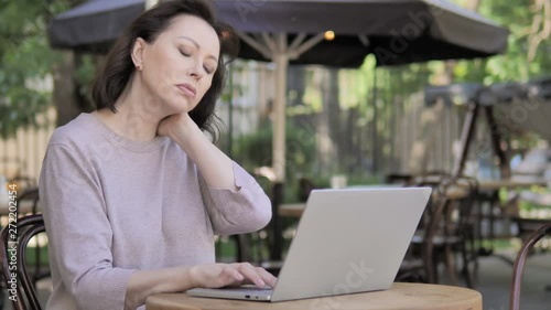 Old Woman with Neck Pain Using Laptop Outdoor