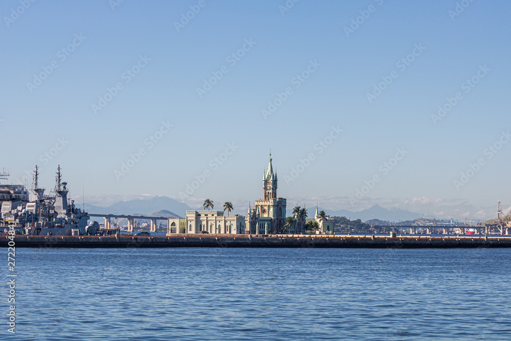 Rio de Janeiro, Brazil -June 07, 2019: The historical building and Fiscal Island (Ilha Fiscal) in the Guanabara bay attached to the naval island with military ship in the background