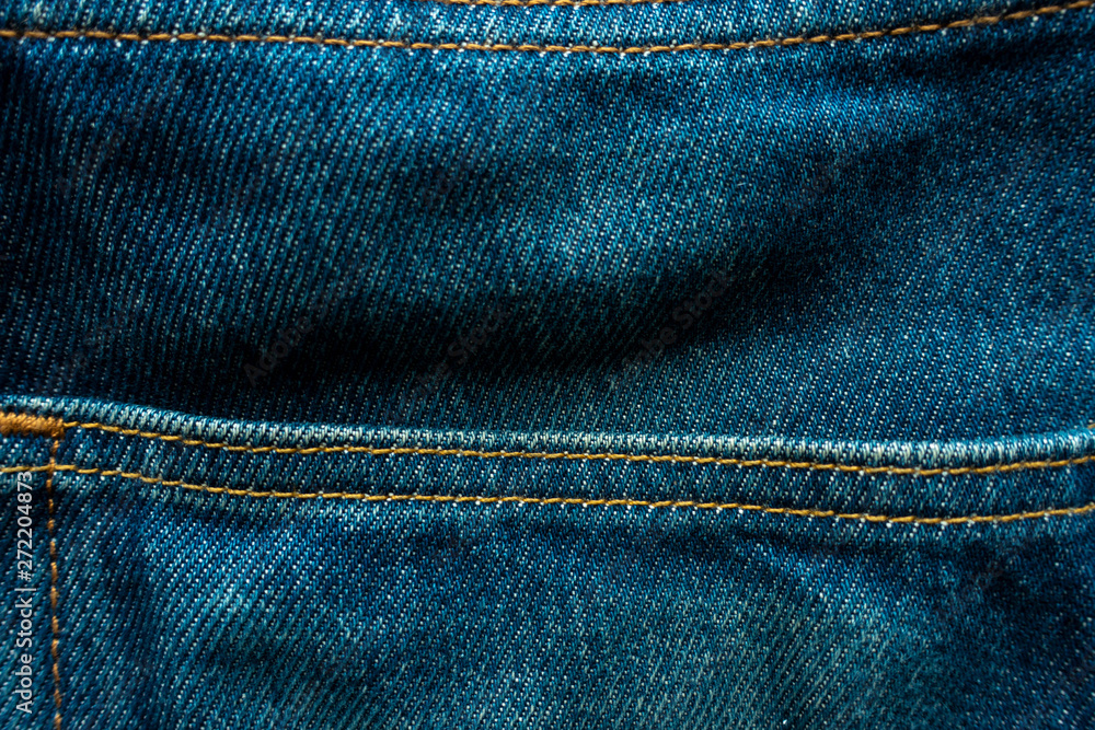 Raw denim jeans faded with yellow stitch for background. Raw denim jeans faded with yellow stitch for background.