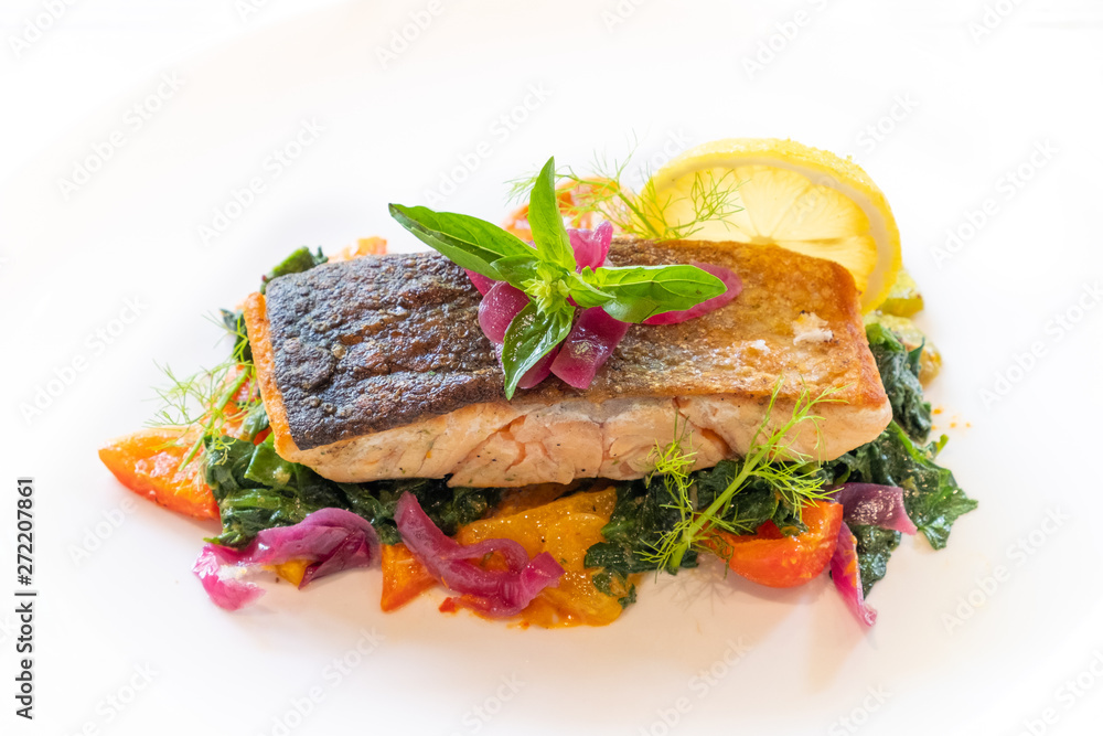 close up of grilled pan seared salmon fillet whit vegetables and sauce italian style close up of grilled pan seared salmon fillet whit vegetables and sauce italian style