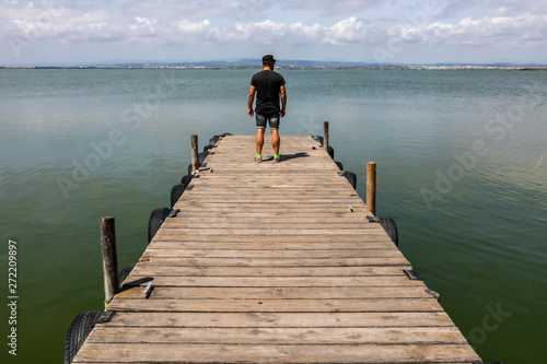 Man On A Dock By The Lake At morning Sky